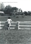 Bridgewater College, Chris Constable looking at horses in pasture, May 1986 by Bridgewater College
