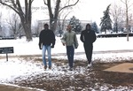 Bridgewater College, Three students smile as they walk toward the camera in snow, February 1986 by Bridgewater College