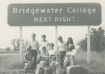 Bridgewater College, Group portrait of students holding representative items by the BC highway sign, circa 1980 by Bridgewater College