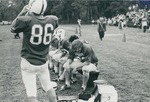 Bridgewater College, Carl Minchew (photographer), Football players on the bench with Ernie the Eagle walking up behind, circa 1969 by Carl Minchew