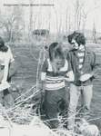 Three students standing by a river, probably Interterm 1972 by Bridgewater College