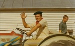 Bridgewater College, A student in a beret driving a tractor and waving at Homecoming, Oct 1969