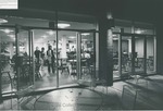 Bridgewater College, Richard W. Linfield (photographer), Nighttime view of students through the doors of the snack bar in the Kline Campus Center, undated by Richard W. Linfield
